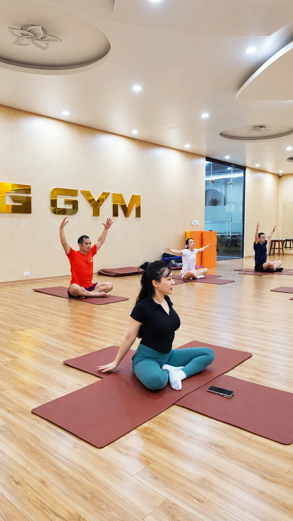 Hội viên tập Yoga trong phòng có sàn gỗ và gương lớn